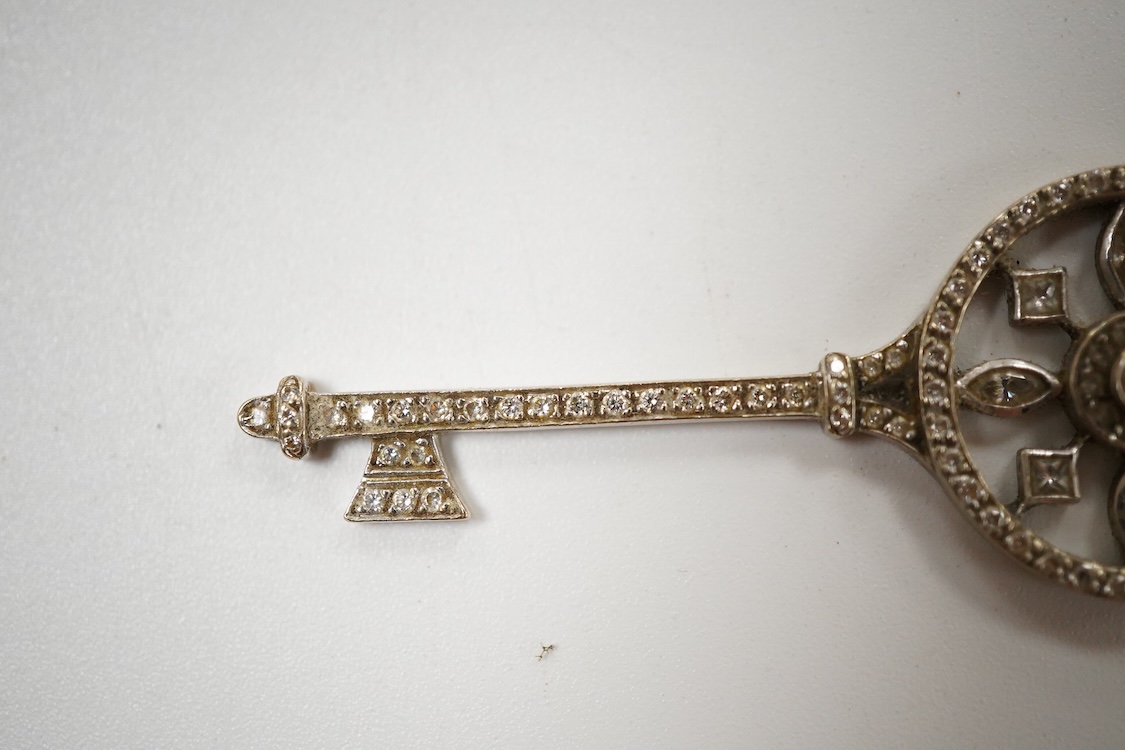 A mid 20th century white metal and diamond cluster set 'key of the door' pendant. 51mm, gross weight 4.6 grams.